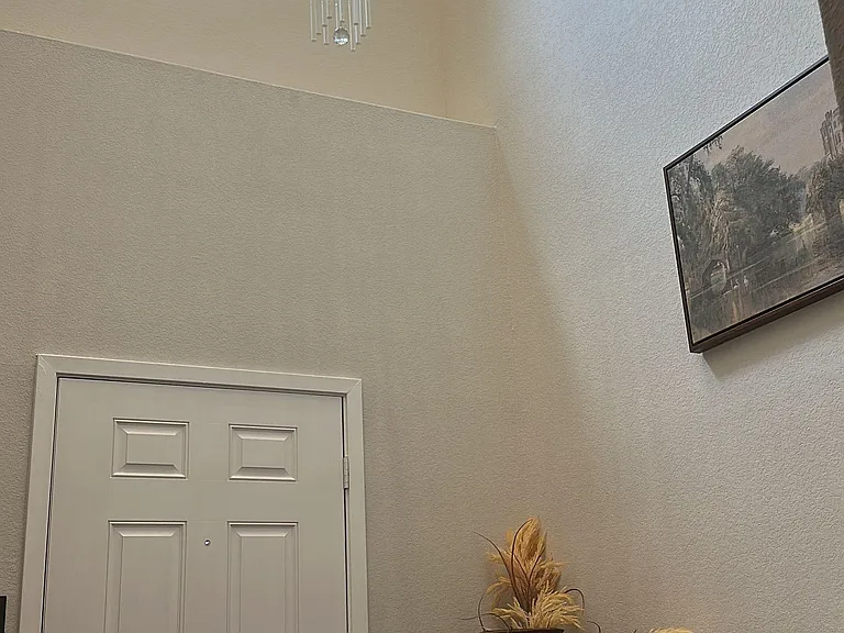 Two-story entry foyer with high ceilings, statement chandelier, and sidelighted front door for easy arrivals.