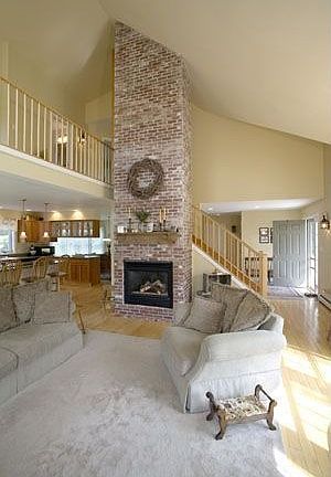 Living room w/ exposed brick fireplace