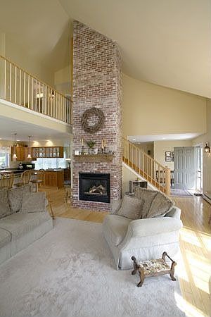 Living room w/ exposed brick fireplace
