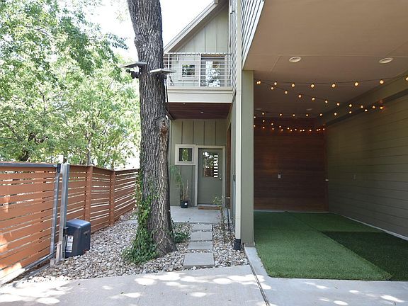 Single car covered car port or outdoor gathering space. Xeriscaped yard behind and on both sides of home.