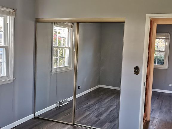 bedroom 1 with two windows and the glass siding door for the closet