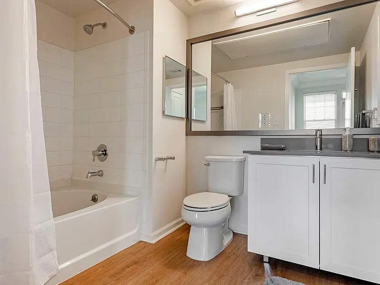 Finish Package II bath with white cabinetry, grey quartz countertops, and hard surface flooring