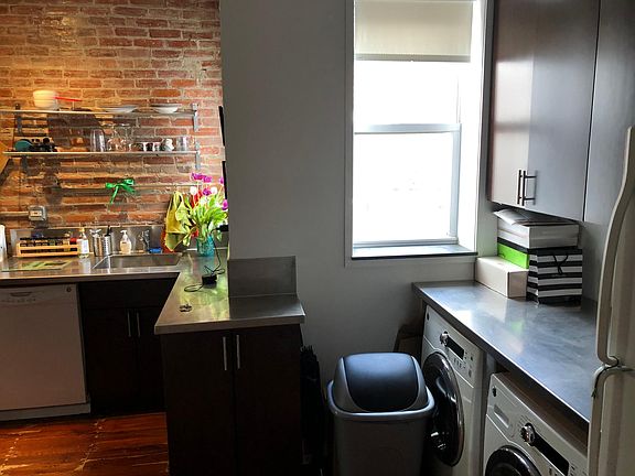 In-unit washer and dryer in the kitchen are beside the full-size refrigerator and by bamboo upper and lower cabinets.