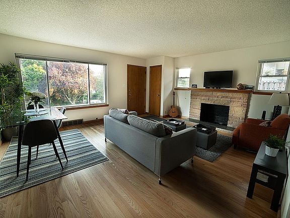 Light-filled picture windows and gorgeous hardwood floors in versatile living.dining area.