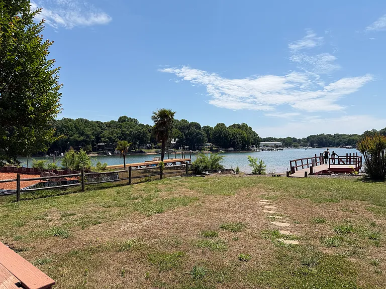 Spacious fenced backyard with unobstructed water views and direct access to the private dock.