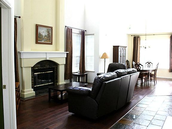 Large family room with hammered hard wood flooring and wonderful natural light