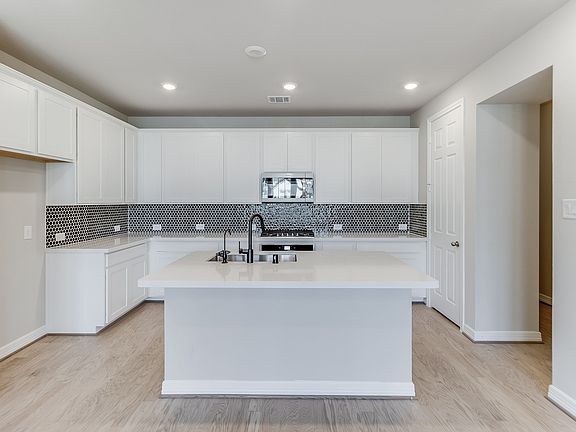 Kitchen with white cabinets and a modern tile backsplash