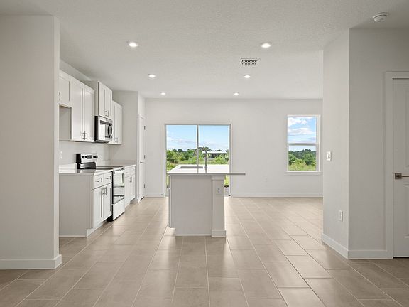 Bright and open-concept kitchen flows into great room with sleek finishes and beautiful backyard vie
