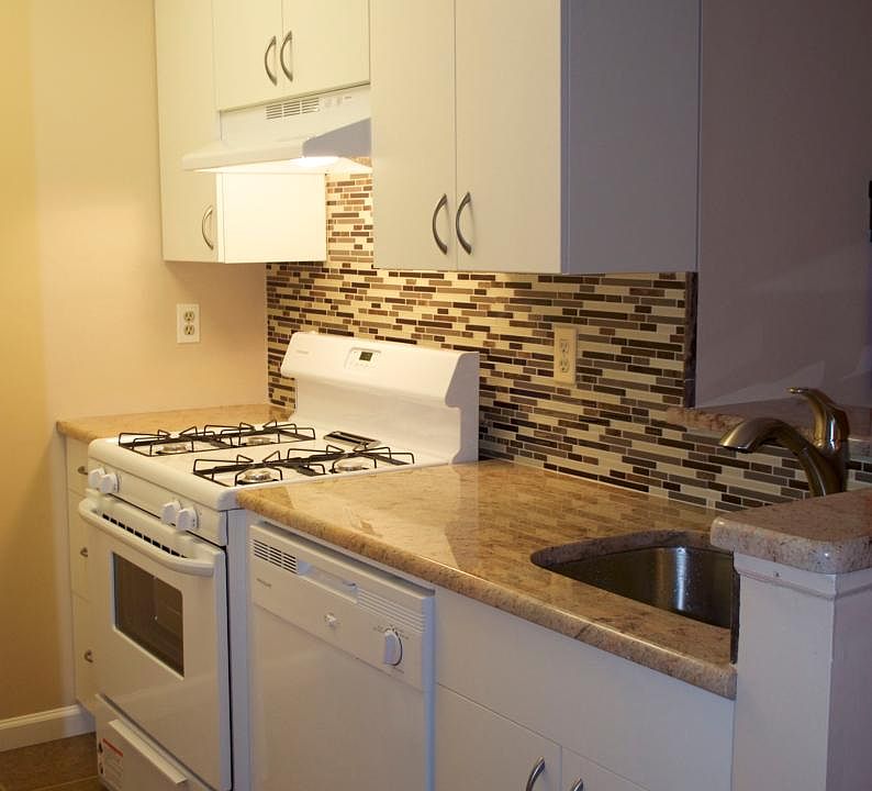 New kitchen, stove, hood, granite countertop, glass tile bac