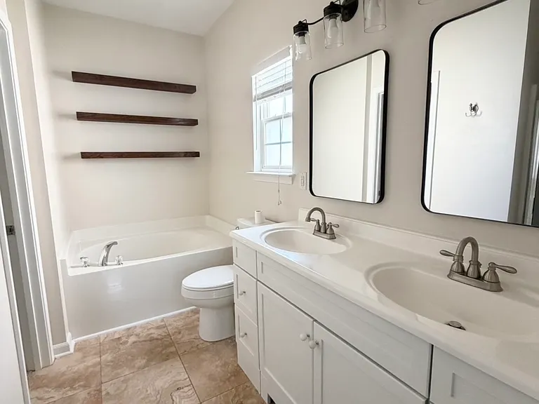 Master bath with dual vanity, tub, standing shower and walk in closet