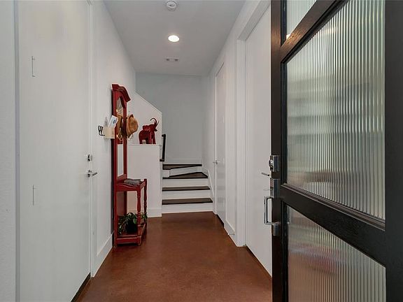 As you enter through the front door you will notice the sleek stained concrete floors, high ceilings, access to your 2 car garage to the left, and coat closet, bedroom with en-suite bathroom and access to your private, fenced backyard to the right.