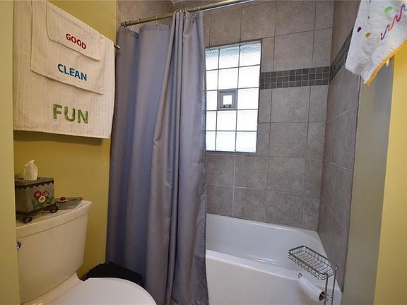 Updated bath includes shower-tub combo with tile surround