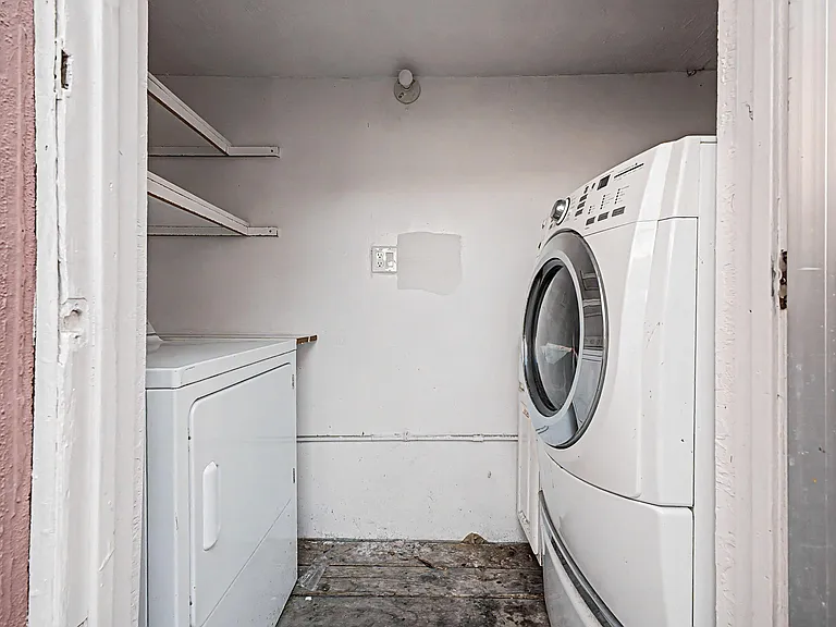 Dedicated laundry nook with in-unit washer/dryer and built-in wall shelving for supplies and extra storage.