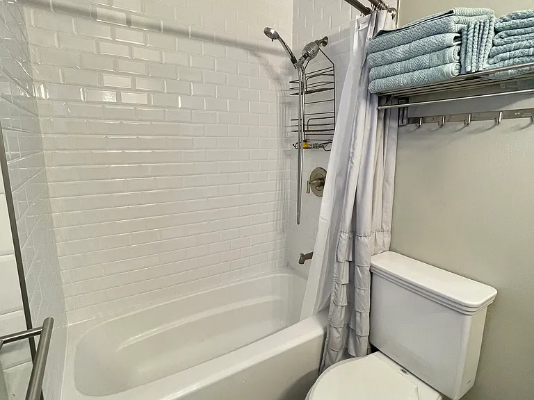 Full bathroom with tub/shower and hairdryer, which is attached to the Master Bedroom
