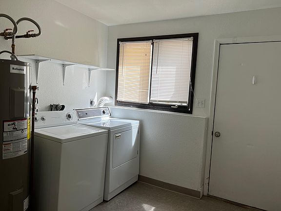 Laundry Room with door to fenced back yard and picnic table
