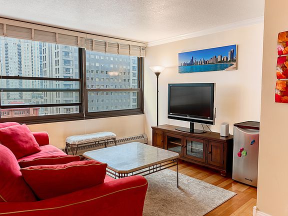 Sun-drenched living room offers abundant natural light and stunning city views, making it the perfect spot to relax or entertain