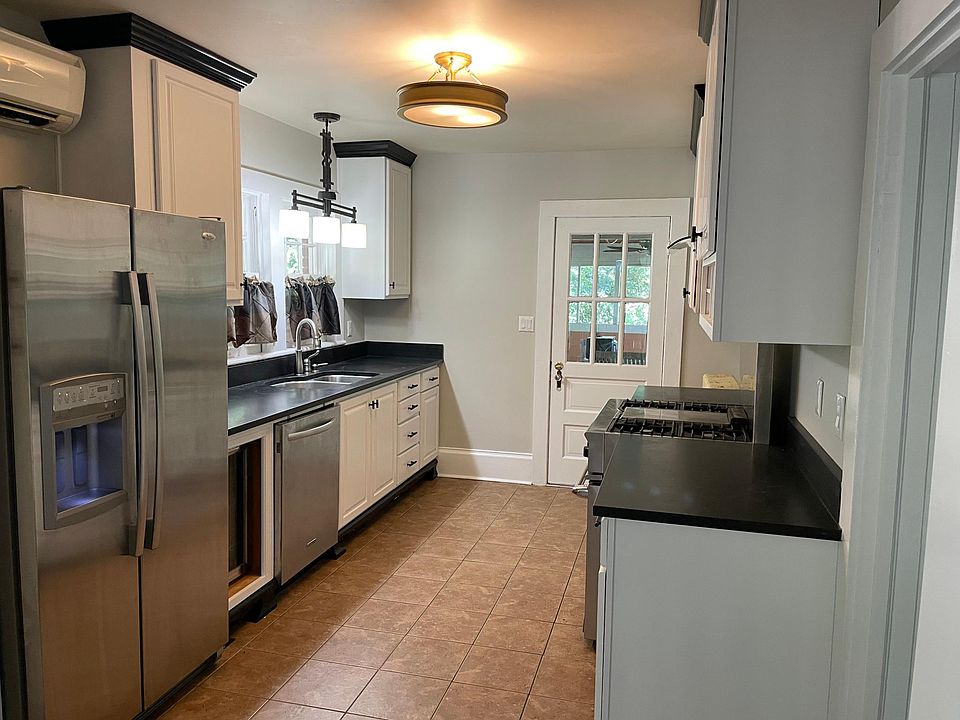 cooks kitchen with 36" gas range, hood, stainless appliances (fridge, dishwasher, undermount sink), solid granite countertops, fresh white cabibets