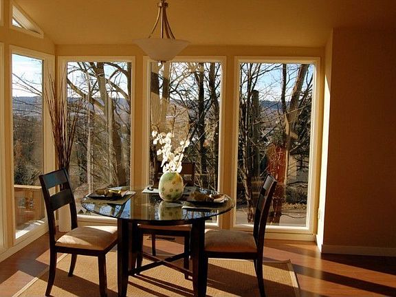 Surrounded by large view windows, this dining room with vaulted ceilings has an elegant feeling.