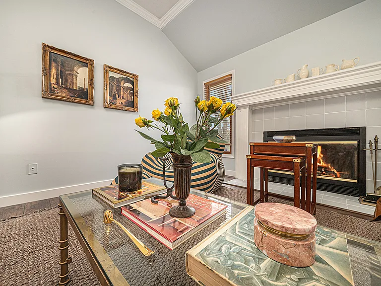 Comfortable seating surrounds a rustic coffee table, creating a natural gathering place for evening chats, board games, or simply enjoying the glow of the fire. Natural light and earthy textures add to the calm, peaceful atmosphere.