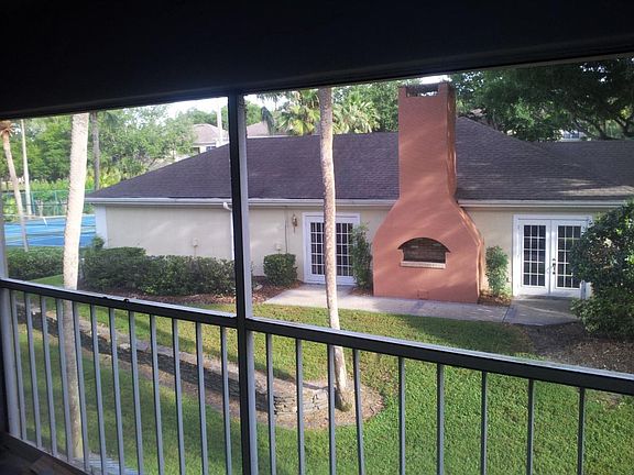 Screened in porch view of clubhouse and tennis courts