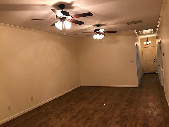 Living room has gas log fireplace and 2 ceiling fans