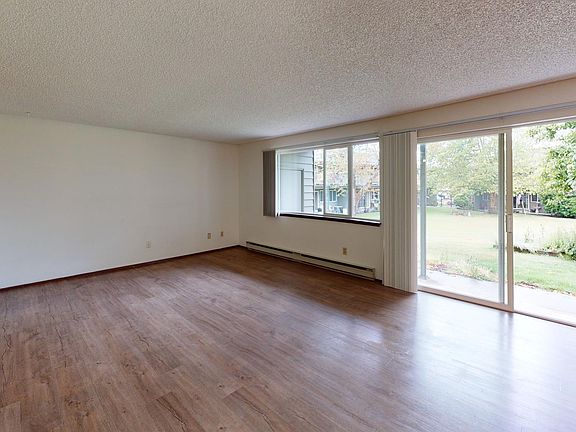 Large living and dining room windows provide plenty of natural light. Living room sliding glass door leads to private deck overlooking community courtyard.