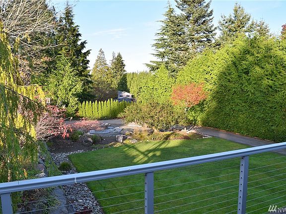 Natural grass backyard with water feature and fire pit in the rear of the property.