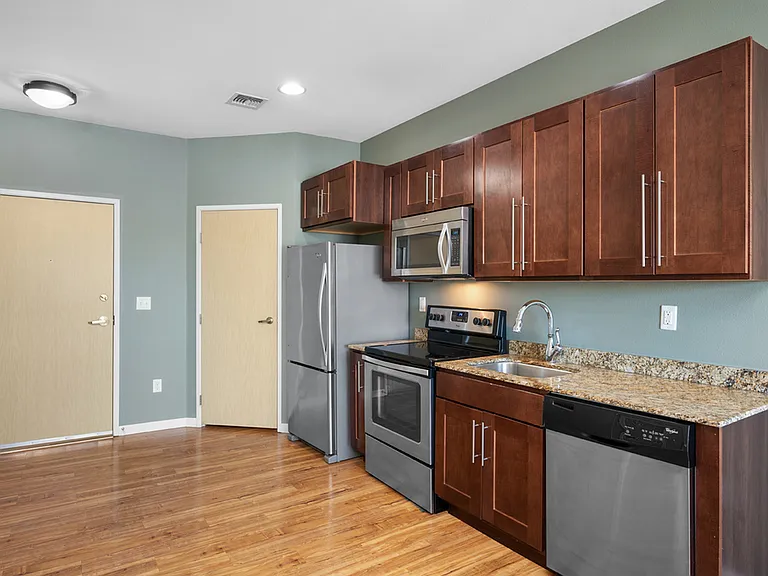 Modern kitchen with sleek stainless steel appliances, rich wood cabinetry, and elegant granite countertops. Modern kitchen with sleek stainless steel appliances, rich wood cabinetry, and elegant granite countertops.