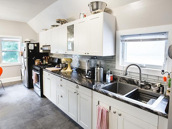 Updated kitchen is well-laid out with plenty of counter space, tile back splash, vent hood over range, and modern, soft-close cabinets.