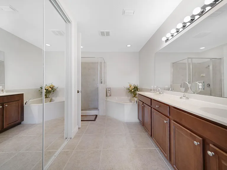 Master Bath with double sinks, separate shower and tub, and private toilet area