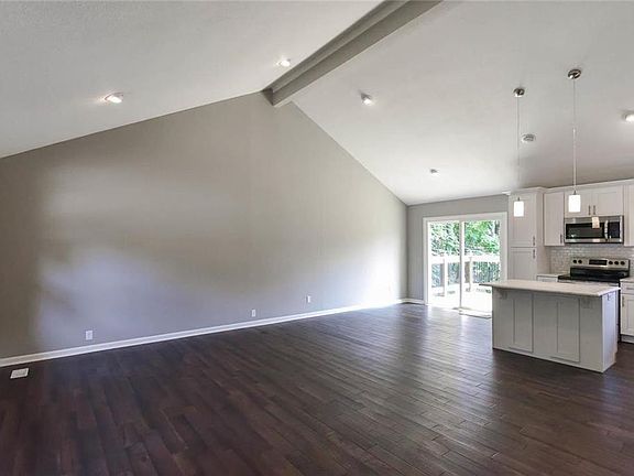 Open floor plan with an island and new stainless steel appliances