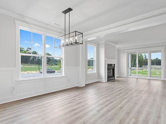 The main level great room and dining room of the Mason at Wendell Falls by Brookfield Residential