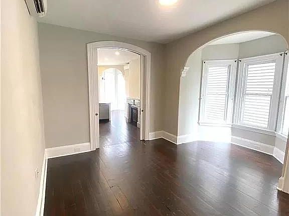 Natural light abounds in this large living room with original hardwood floors.