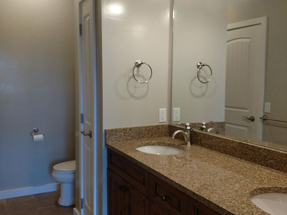 En suite bath with double sinks and granite countertops