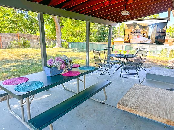 Your private backyard escape with cozy seating, a dining table, and a projector for ultimate relaxation!