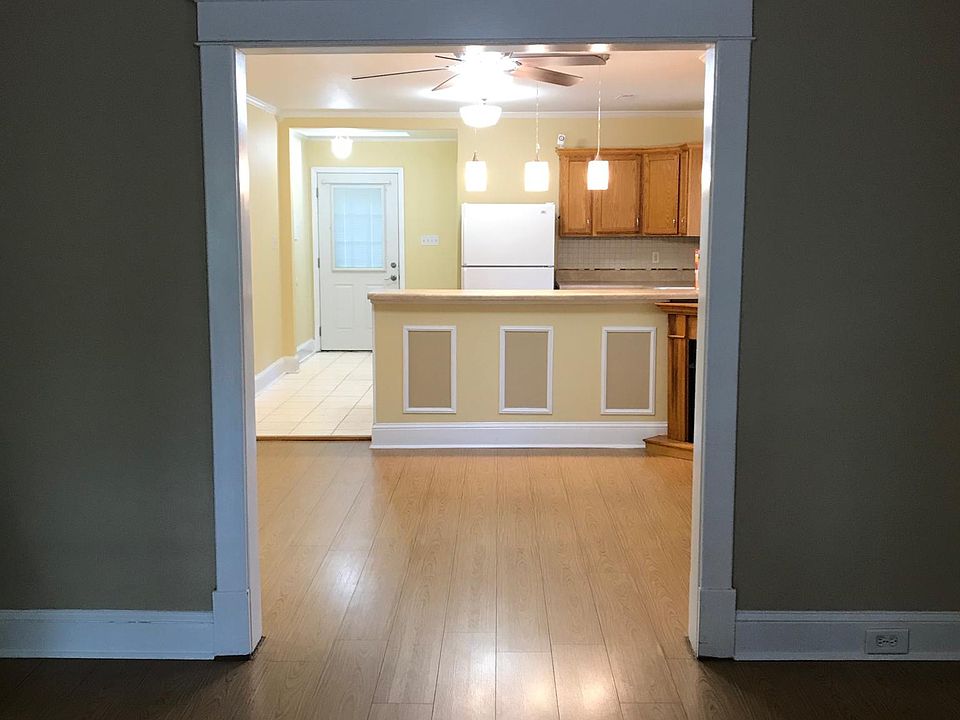 Bright open kitchen with breakfast bar and ample counter space comes fully stocked with refrigerator, stove, built-in microwave and spacious wooden cabinetry.
