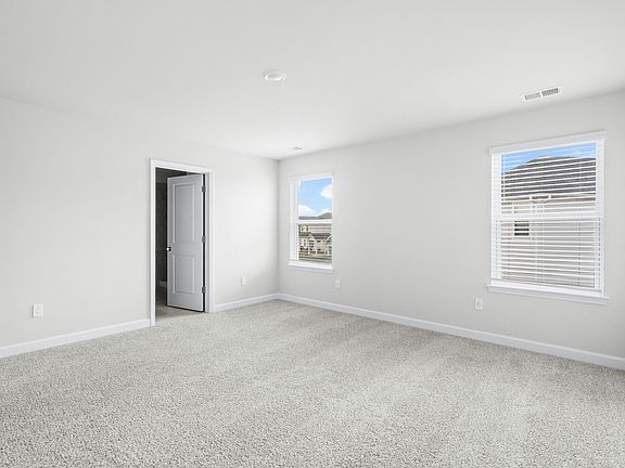 Relax and recharge in the spacious, light-filled primary suite.