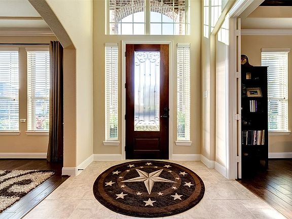 Beautiful mahogany door and entry with tall ceilings. Home office/study on the left with French doors, formal dining room is on the right.