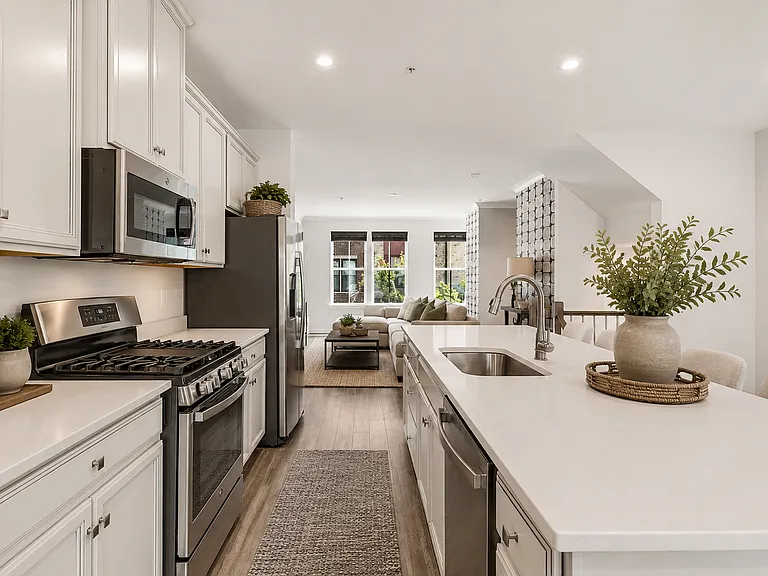 oversized quartz island, designer cabinetry, stainless steel appliances, gas cooking offers the ideal entertaining space (Photos are virtually staged)