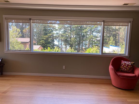 Living room view #2. There's a peek view of the bay through the trees