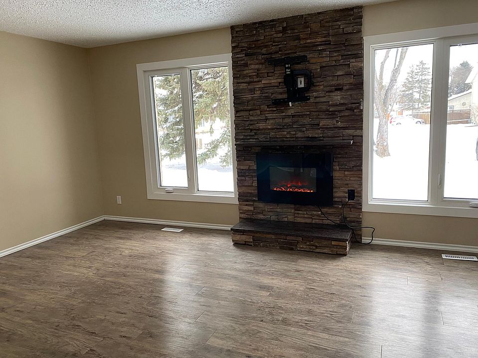 Look at this spacious room where you can cozy up to the fireplace all winter long. These large windows allow light to flood in and there_s a built in stand to hang the flat screen TV! Just imagine your Christmas tree in the corner. : )