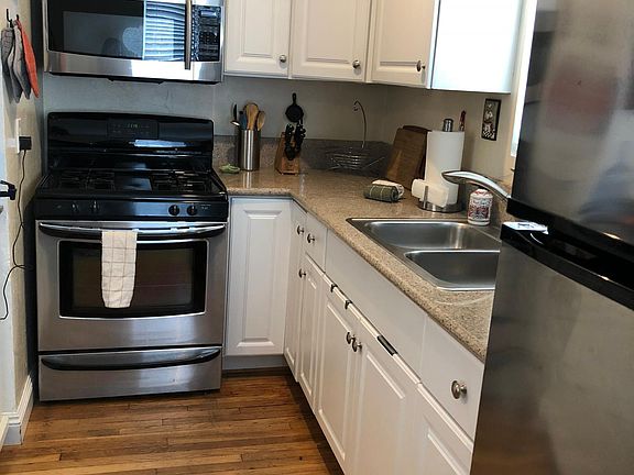 galley kitchen contains oven/stove, microwave, coffee maker, toaster oven, all implements, fridge and freezer