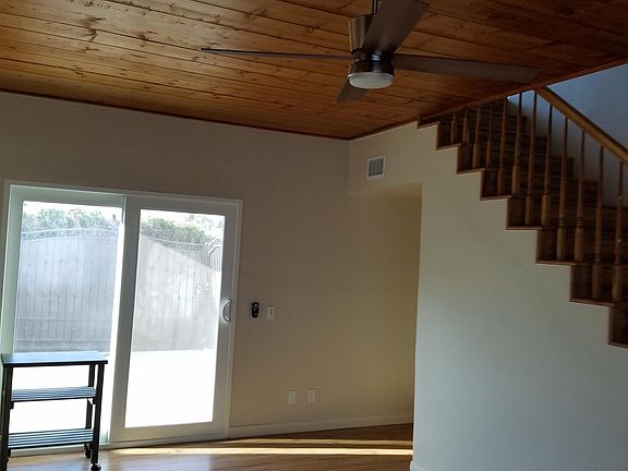Living room with laminate flooring and dimmable ceiling fan.