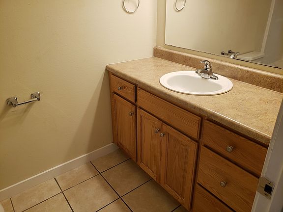 Wood vanity with tile flooring.