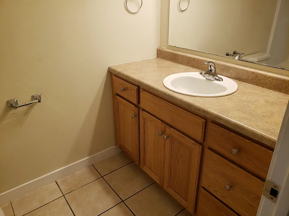 Wood vanity with tile flooring.