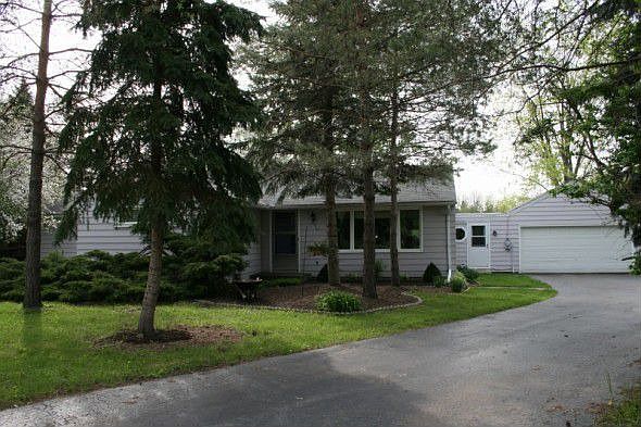 The front of the house is surrounded by beautiful trees