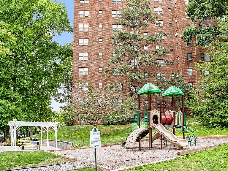 Experience community living at its finest with a delightful playground surrounded by greenery.