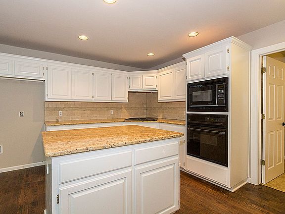 Newly remodeled open Kitchen boasts gorgeous granite counters, granite island with storage, tumbled marble backsplash, recessed lighting and brushed nickel finishes.