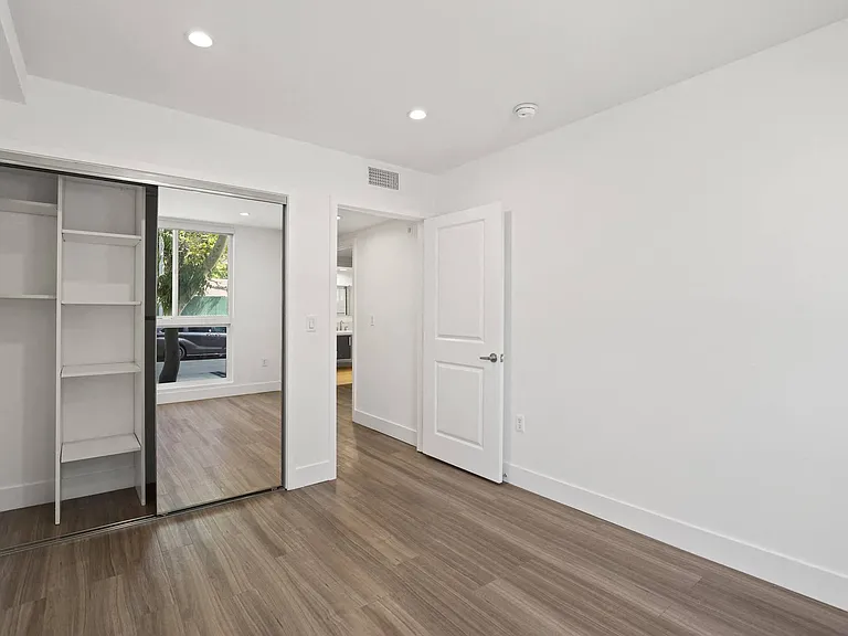 Bedroom with Mirrored Closet with Shelving, Recessed Lighting, and Vinyl Floors