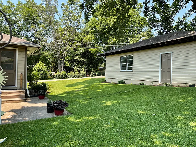Back door and patio. Large detached garage with built in work bench. Slightly sloping back yard.